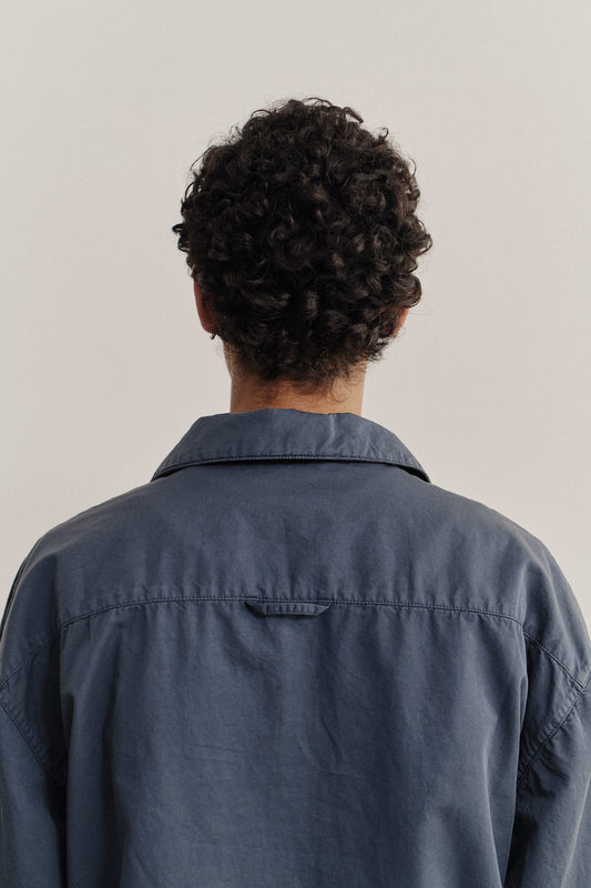 Men's long-sleeved shirt jacket, cotton-linen blend, garment dyed blue, with a spread collar and dropped shoulders.