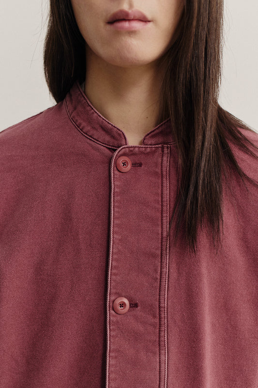 Women's outerwear jacket, organic cotton stone-washed, faded red, with stand collar and buttoned front.
