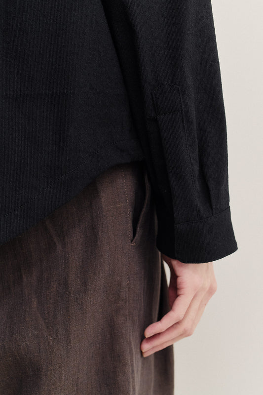 Men's long-sleeved shirt, black cotton blend with irregular wavy stripes, dropped shoulder, and adjustable cuffs.