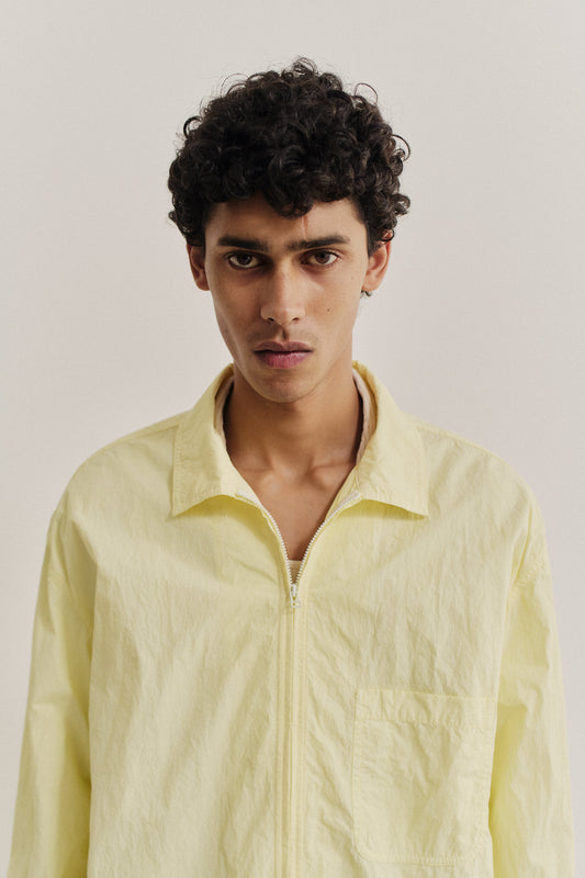 Men's long-sleeved shirt, recycled polyamide, garment-dyed light yellow, with two-way zipper and patch pocket.