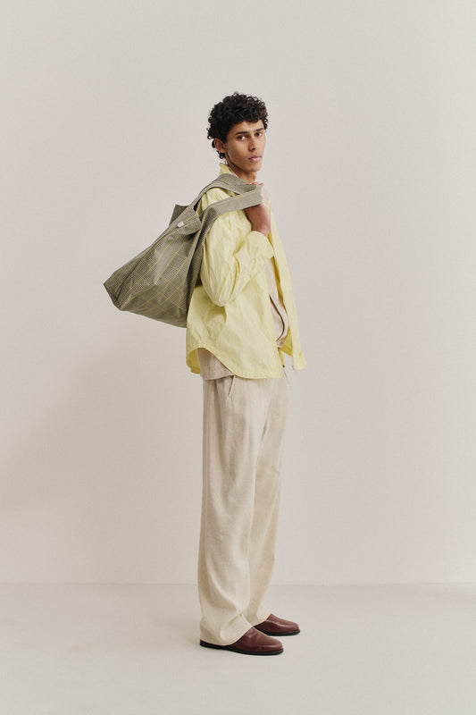 Men's long-sleeved shirt, recycled polyamide, garment-dyed washed light yellow, oversized, with a checked tote bag.