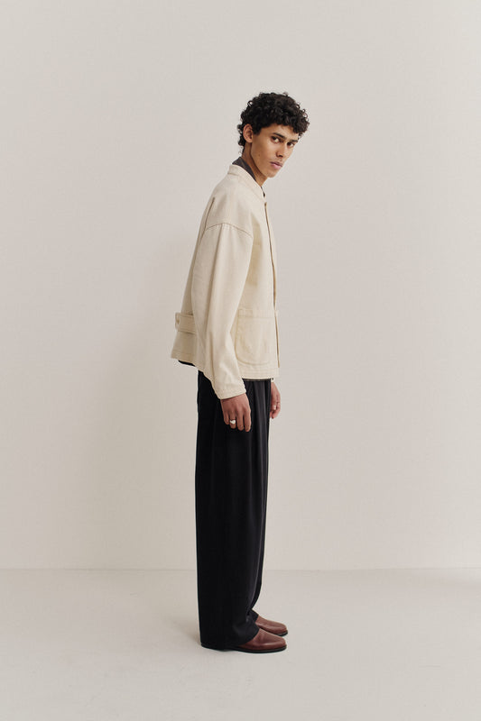 Men's outerwear jacket, organic cotton raw denim, off-white, boxy fit, stand-up collar, patch pockets.