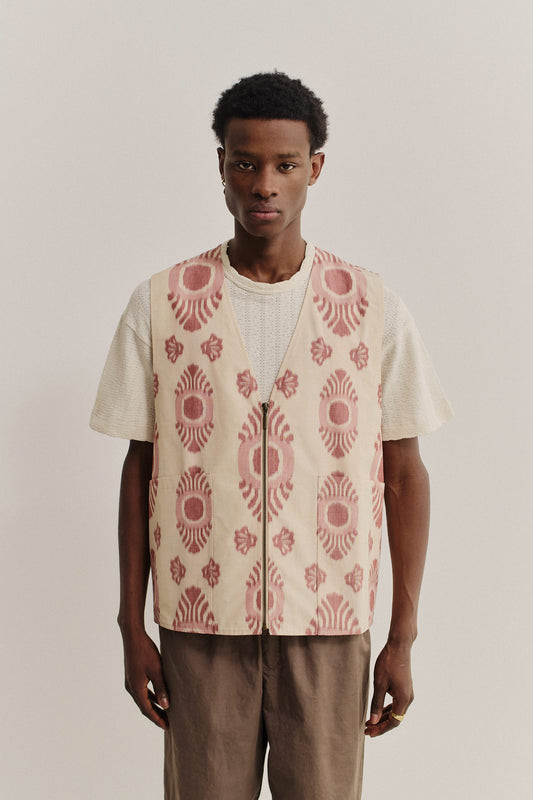 Men's outerwear vest, cotton-recycled polyester blend, ikat-patterned beige and red, metal zipper, oversized fit.