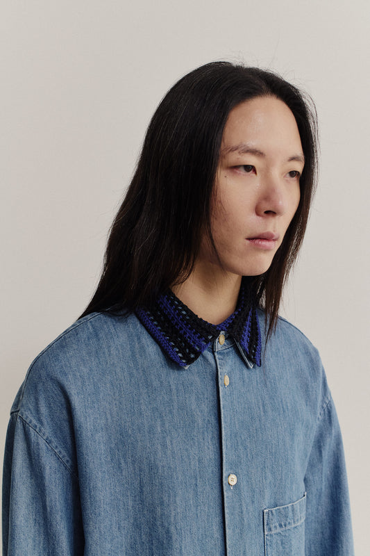 Women's accessories, hand-crocheted Kikoy Collar in black and purple merino wool, worn over a denim shirt.