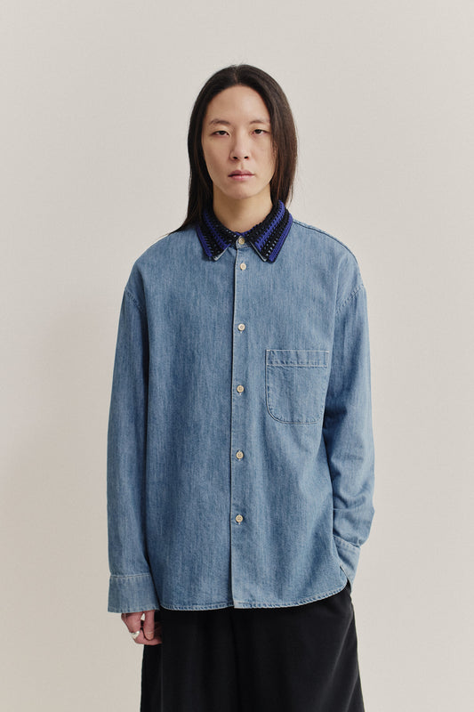 Women's accessories, hand-crocheted Kikoy Collar in blue and black merino wool, worn over a denim shirt.