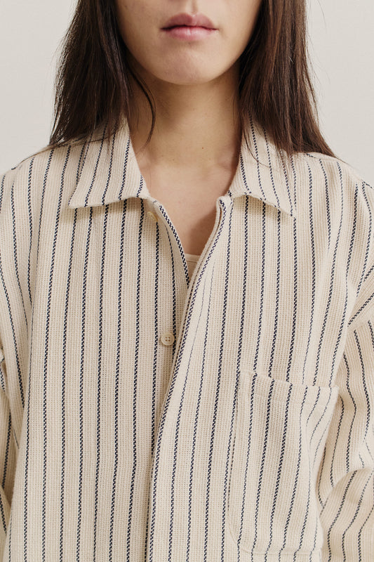 Women's long-sleeved shirt, off-white cotton blend with navy vertical stripes, spread collar, and patch pocket.