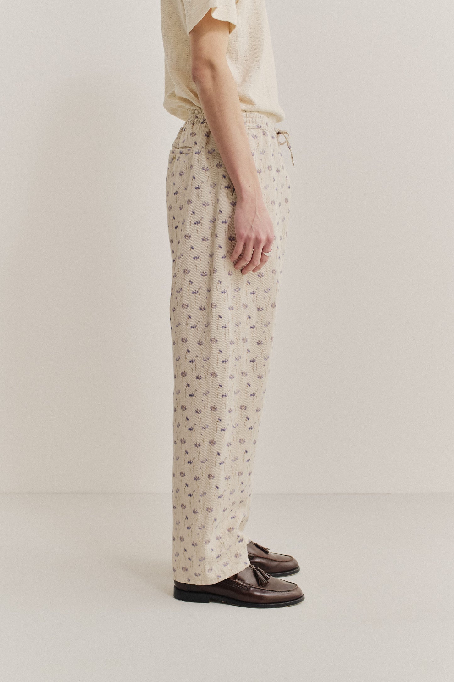 Men's long pants, cotton-linen twill, ecru with subtle lilac and brown floral print, elastic waist.