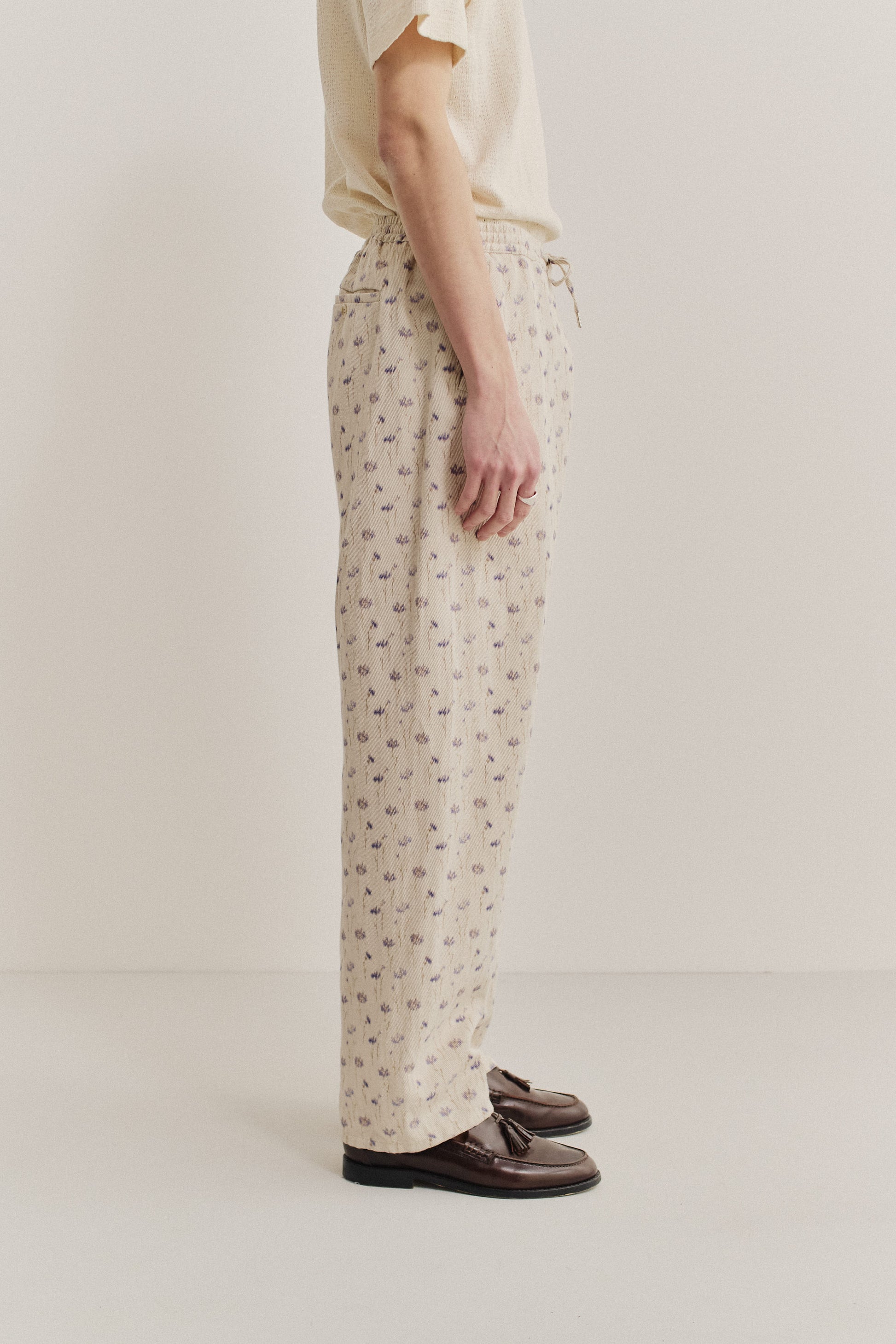 Men's long pants, cotton-linen twill, ecru with subtle lilac and brown floral print, elastic waist.