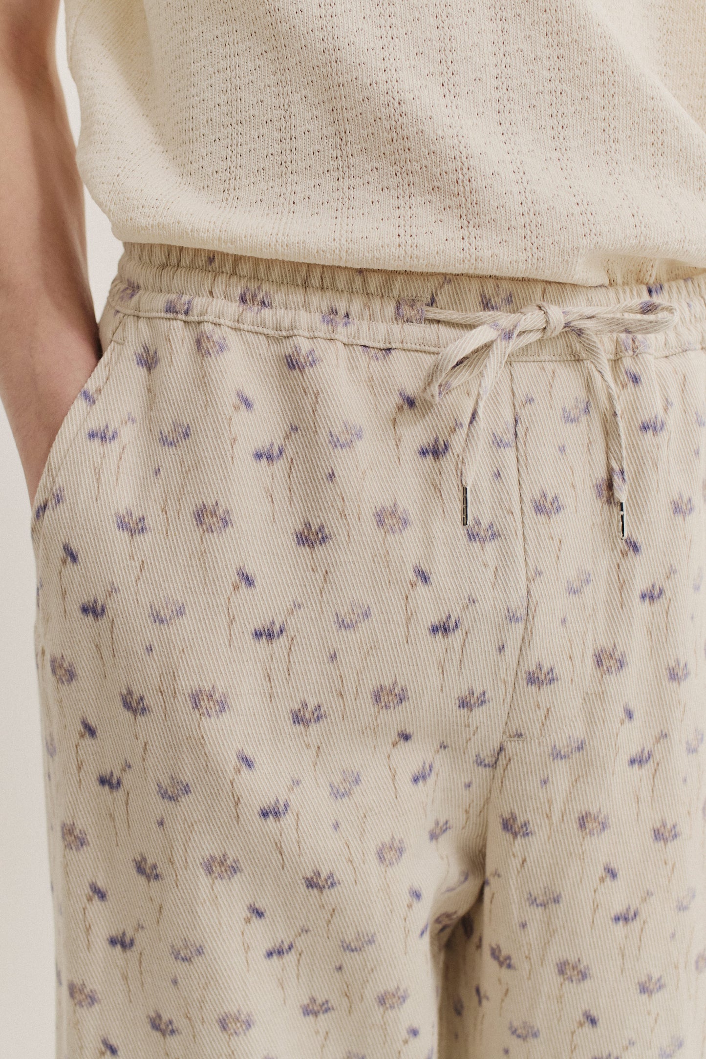 Men's long-pants, cotton-linen blend twill, ecru with subtle lilac and brown floral print, elastic waist.