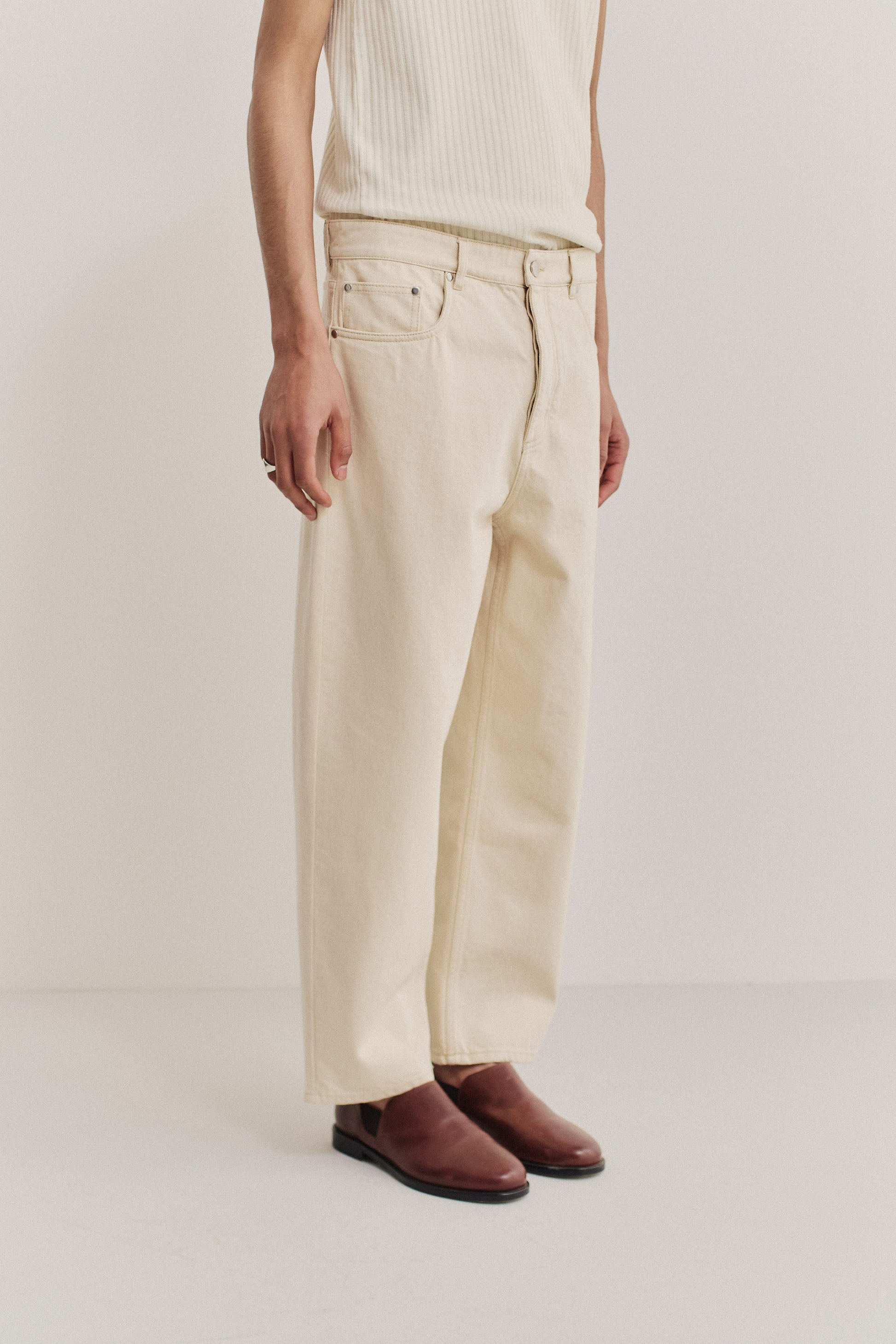 Men's long-pants, organic cotton raw denim, pre-washed off-white, loose fit, tapered leg, cropped length.