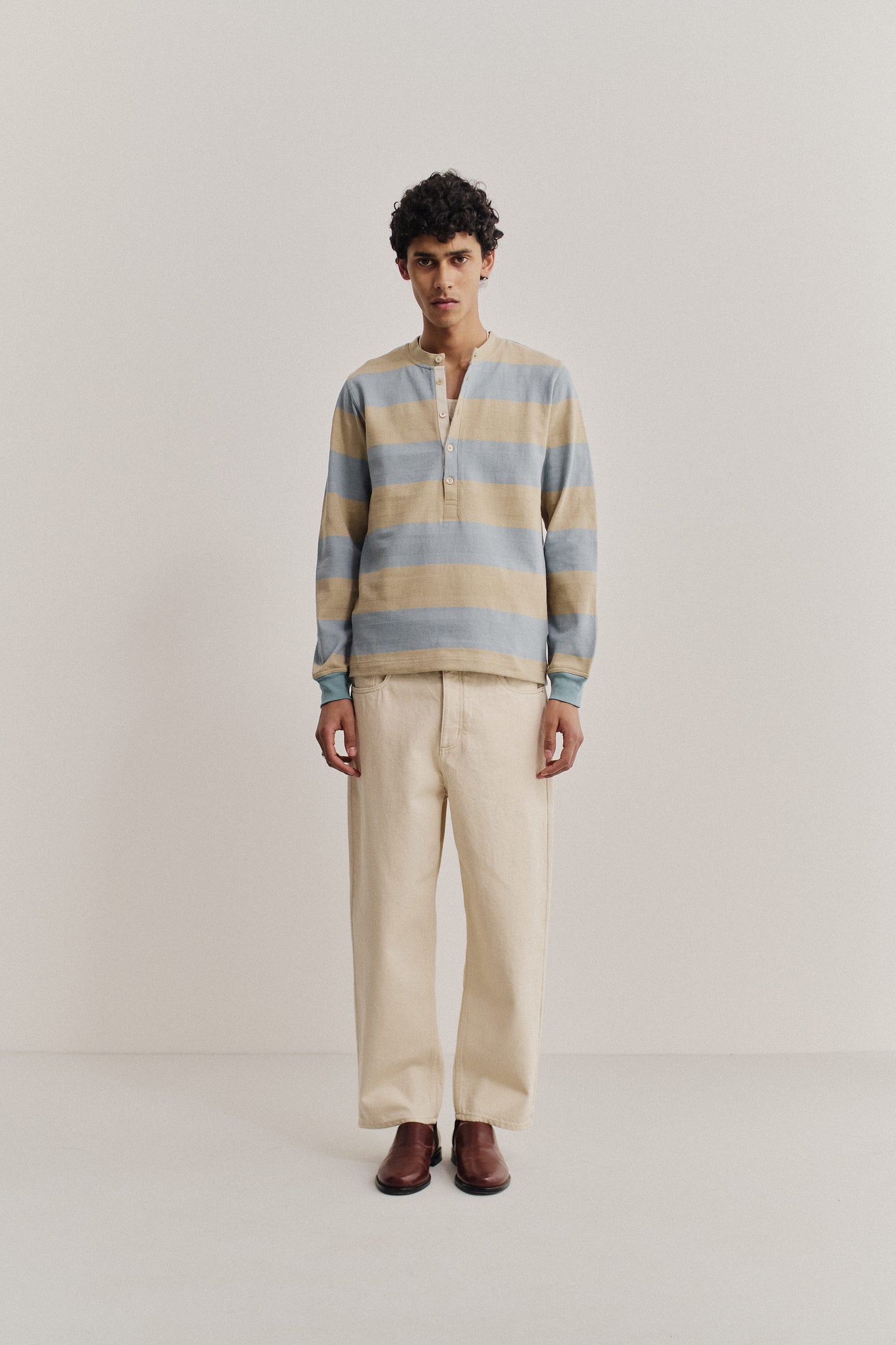 Men's long-pants, organic cotton raw denim, off-white, loose fit, tapered leg, cropped length.
