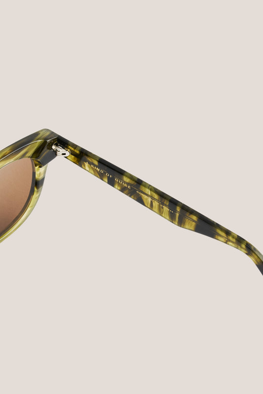 Unisex accessories sunglasses, round-shaped curvy acetate frame in green tortoise with brown lenses.