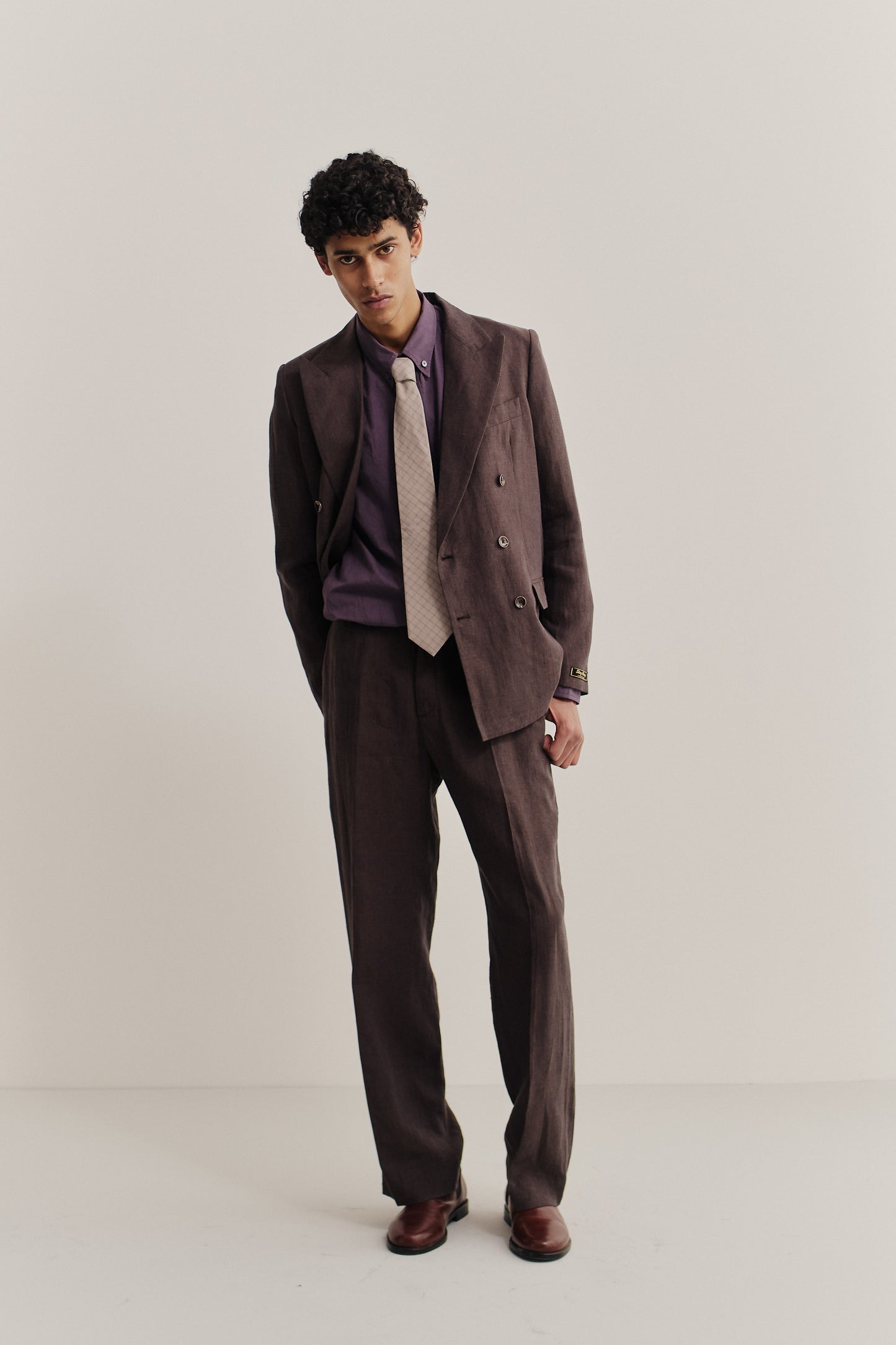 Men's tailoring, long-pants, and long-sleeved shirt, cotton, brown suit with purple shirt and beige tie.