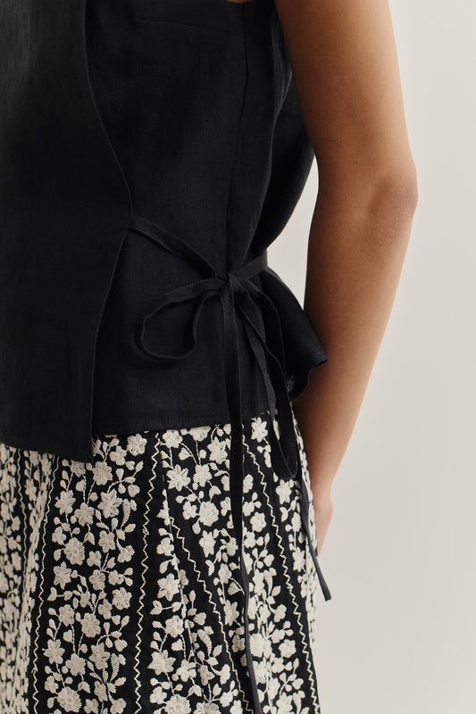 Women's sleeveless wrap shirt in black 100% linen, with an adjustable side tie.