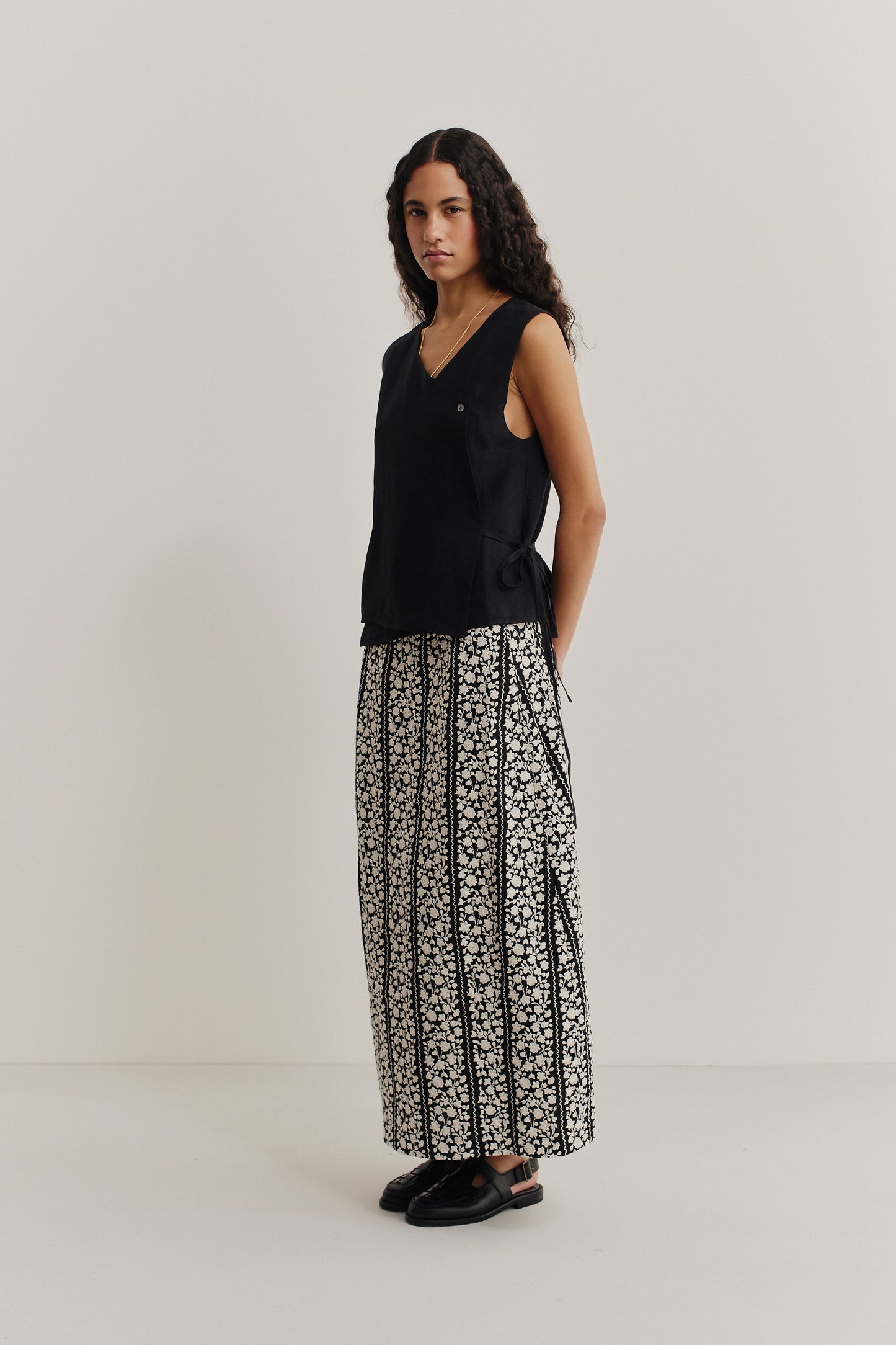 Women's sleeveless wrap shirt, 100% black linen, with V-neckline and side tie.