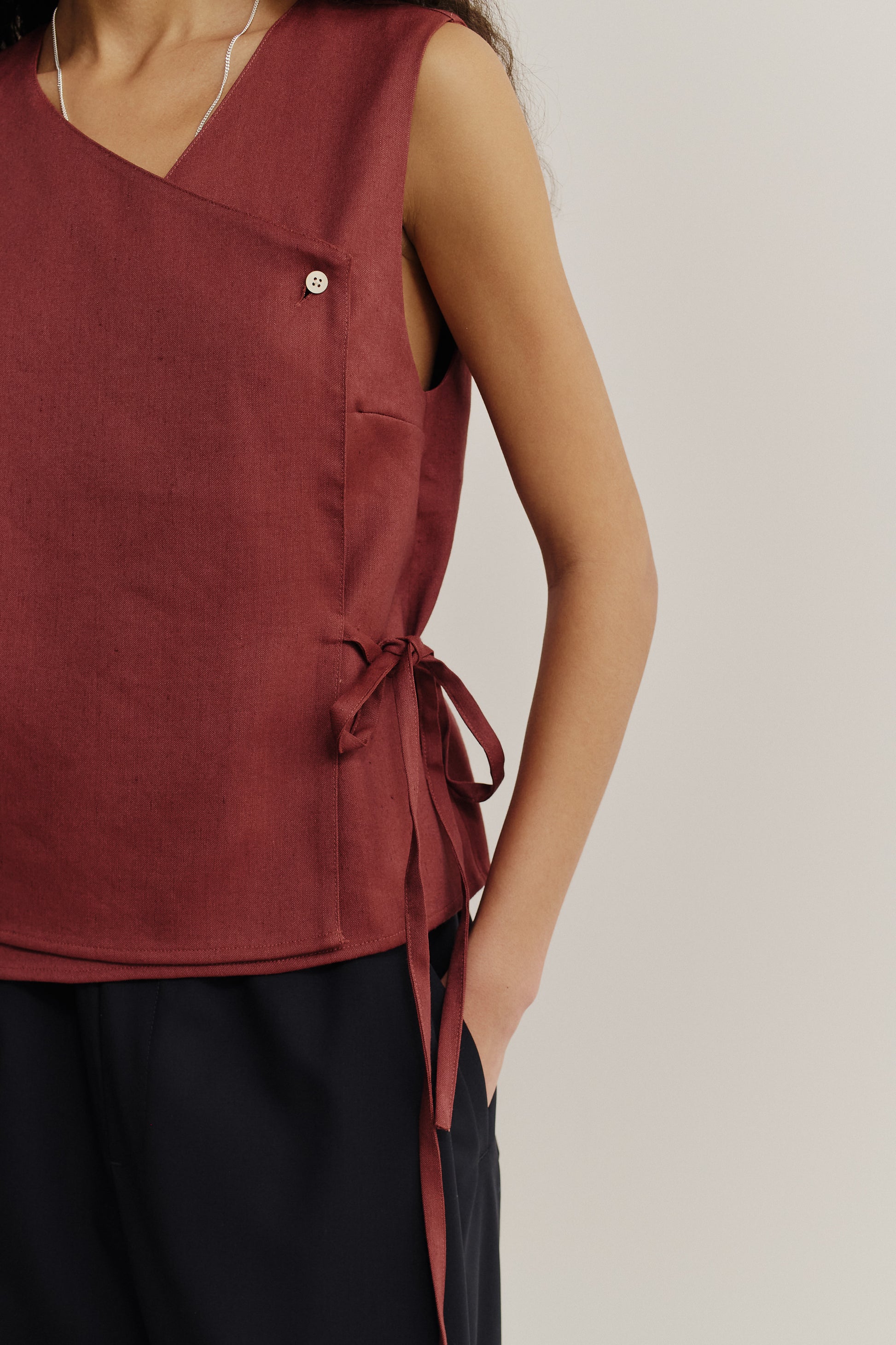 Women's sleeveless wrap shirt in linen-virgin wool-mohair blend, featuring an asymmetric front, V-neck, and side ties, in a prune color.