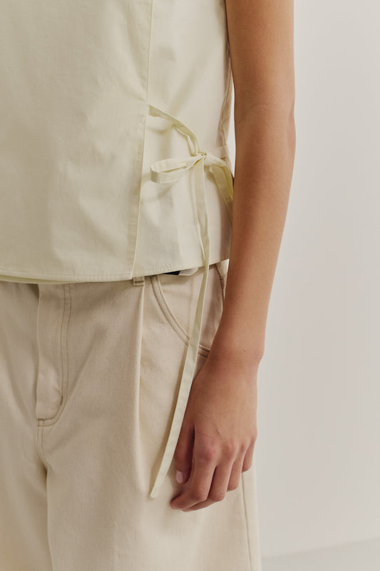 Women's sleeveless wrap shirt, organic cotton, garment washed, light yellow, with side ties.