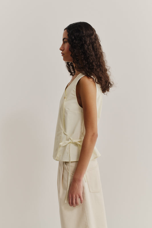 Women's sleeveless wrap shirt, organic cotton, garment washed, light yellow, with side ties.