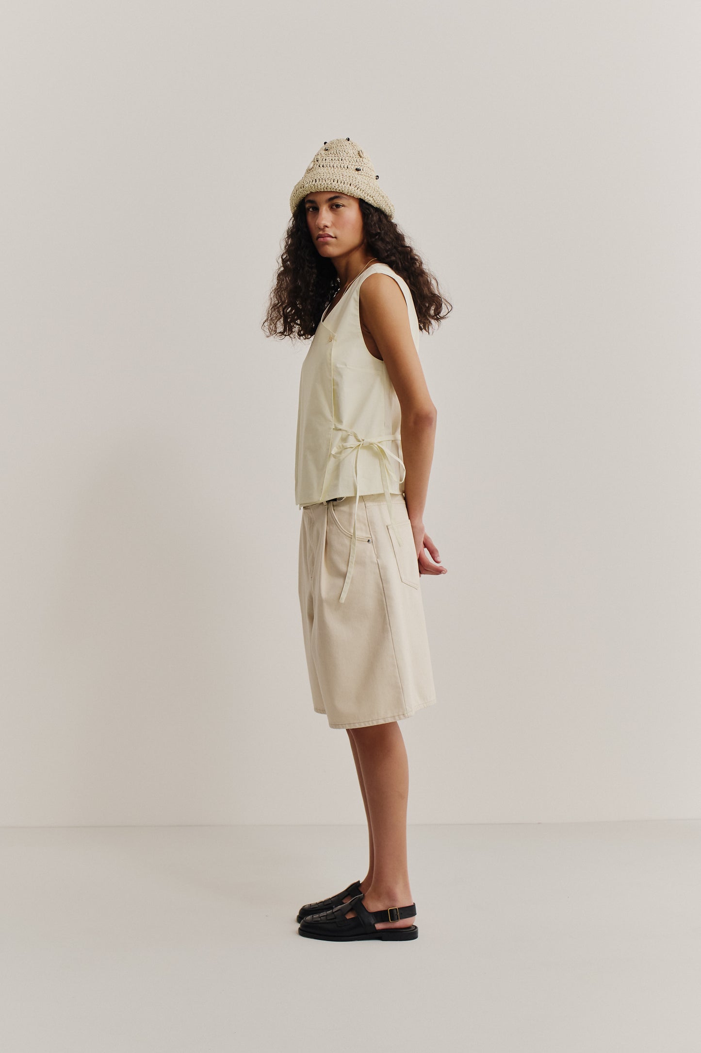 Women's sleeveless wrap shirt, organic cotton, garment washed, light yellow, with adjustable side ties.