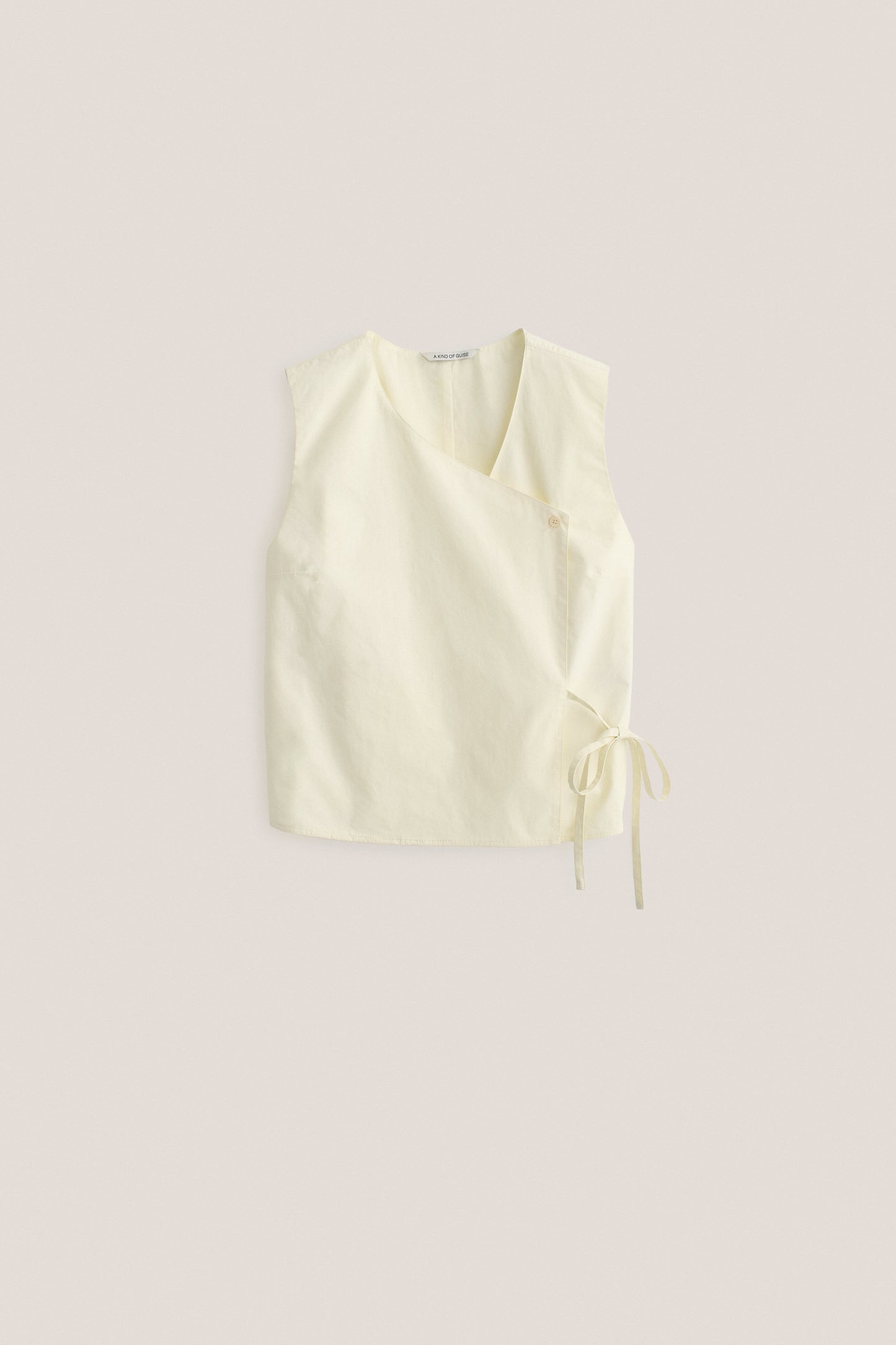 Women's sleeveless wrap shirt, organic cotton, garment washed, light yellow, with V-neck and side ties.