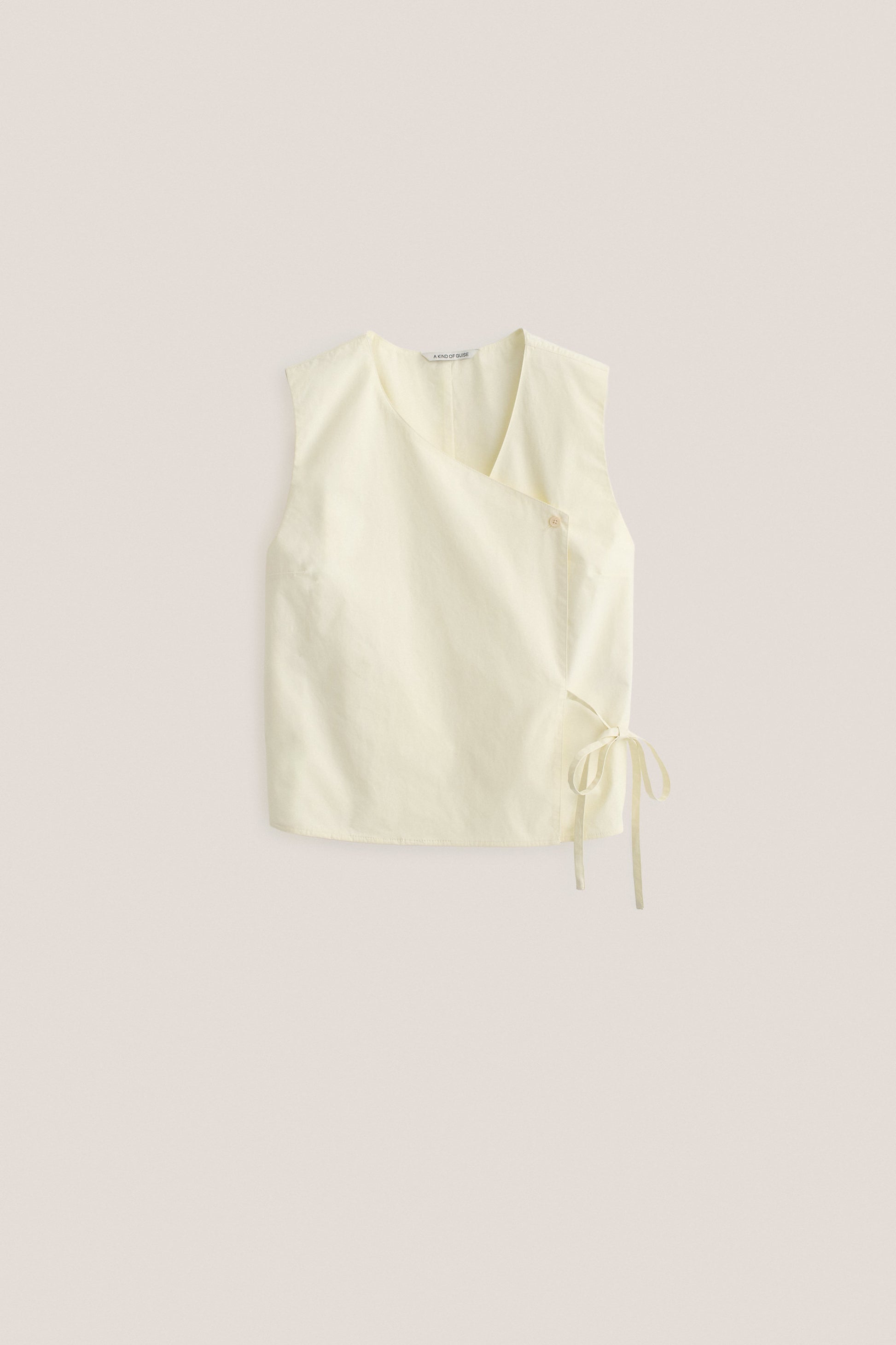 Women's sleeveless wrap shirt, organic cotton, garment washed, light yellow, with V-neck and side ties.