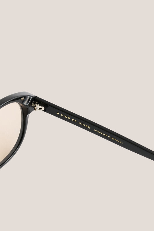 Unisex accessories sunglasses, black acetate aviator frame with rounded vintage edges and light peach lenses.