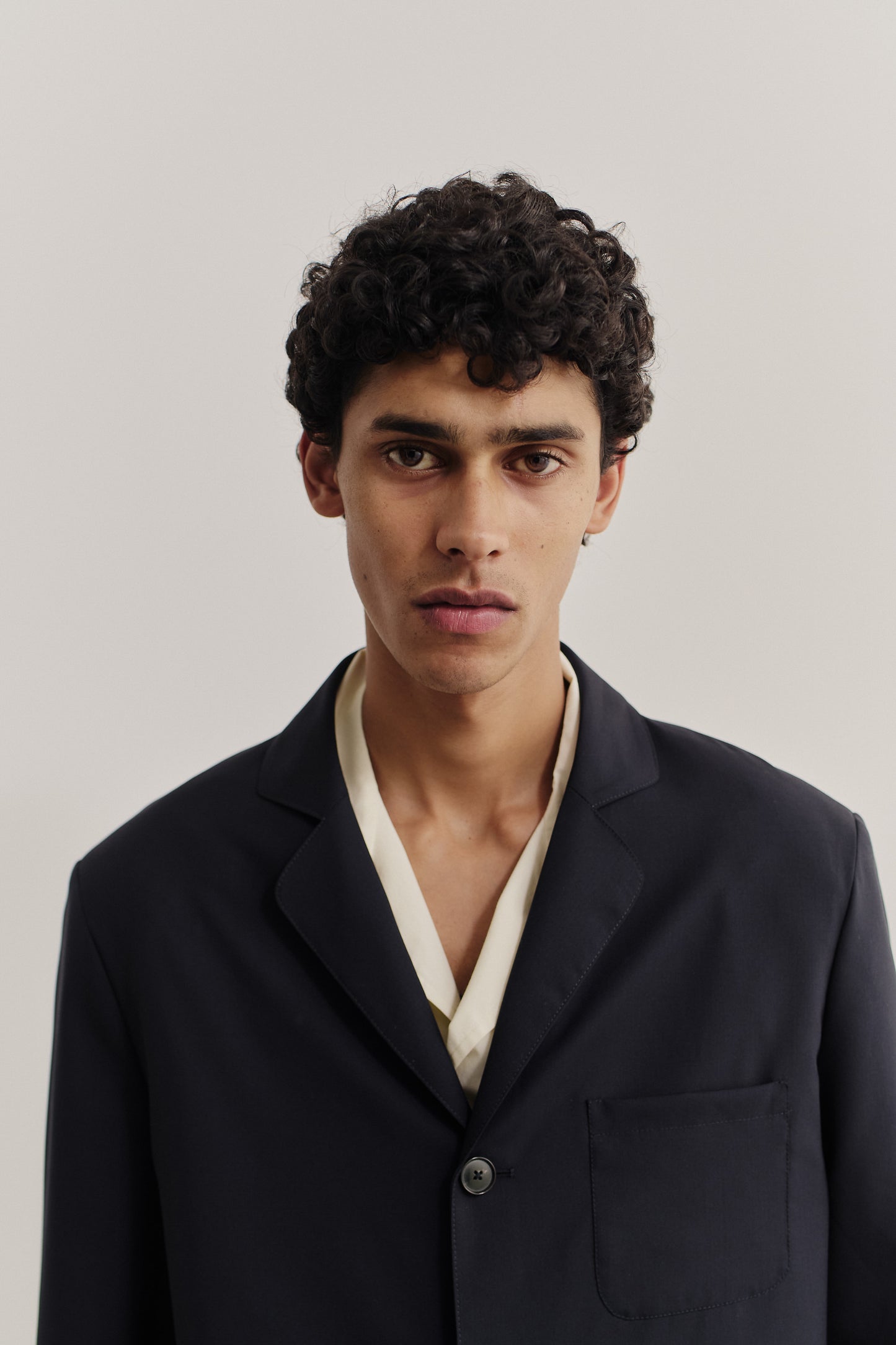 Men's tailoring, oversized deconstructed atelier blazer in dark navy virgin wool, with rounded lapel and patch pocket.