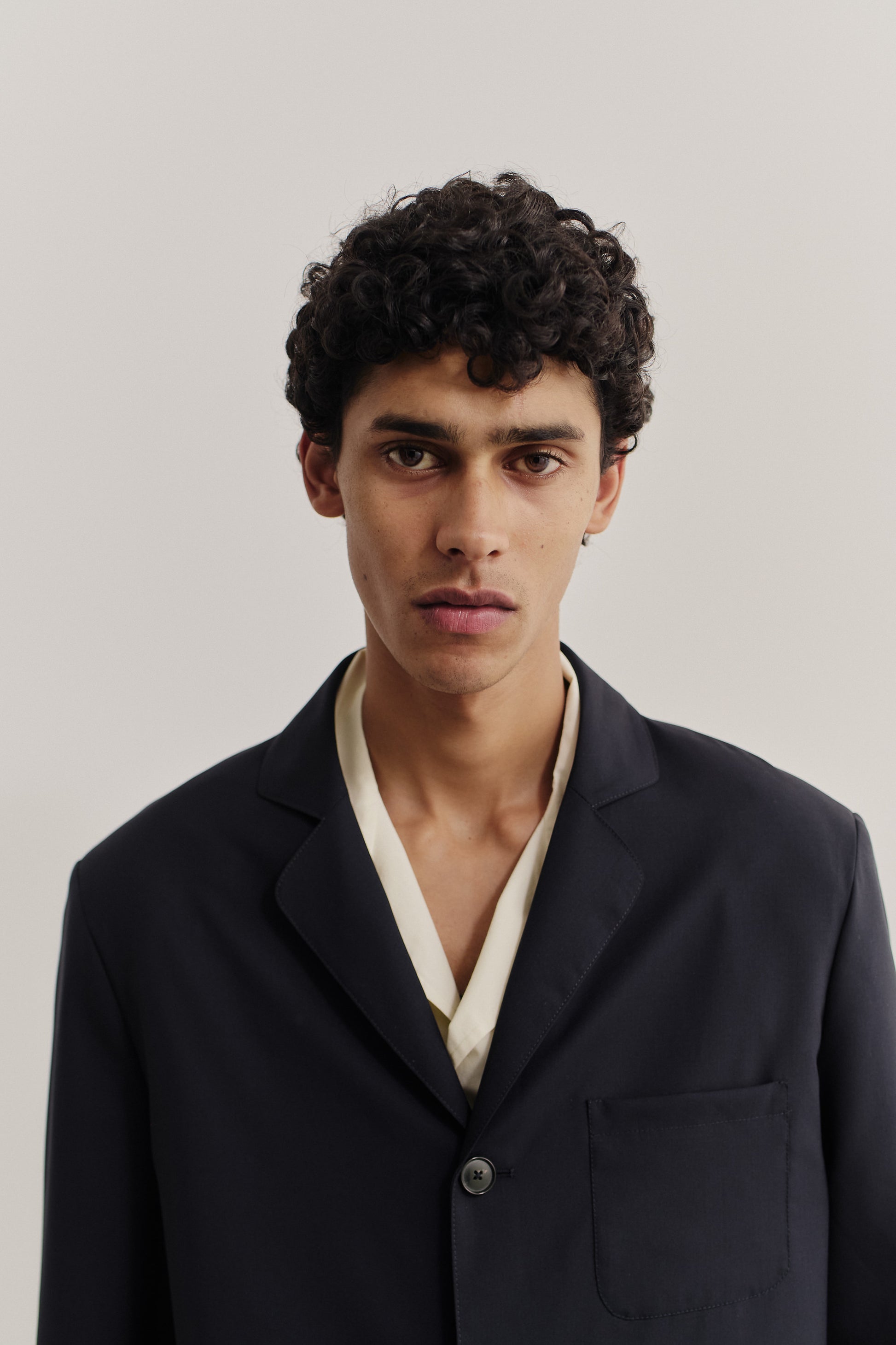 Men's tailoring, oversized deconstructed atelier blazer in dark navy virgin wool, with rounded lapel and patch pocket.