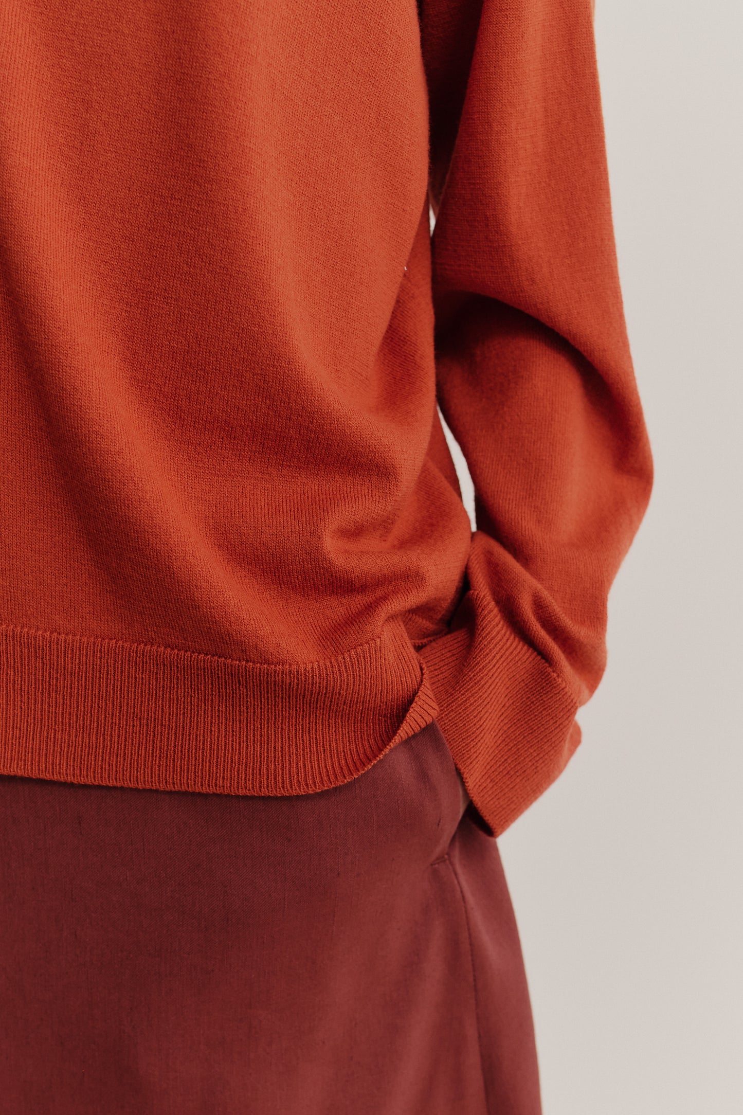 Women's knit cardigan, 100% merino wool, rust orange, relaxed fit with ribbed trims.