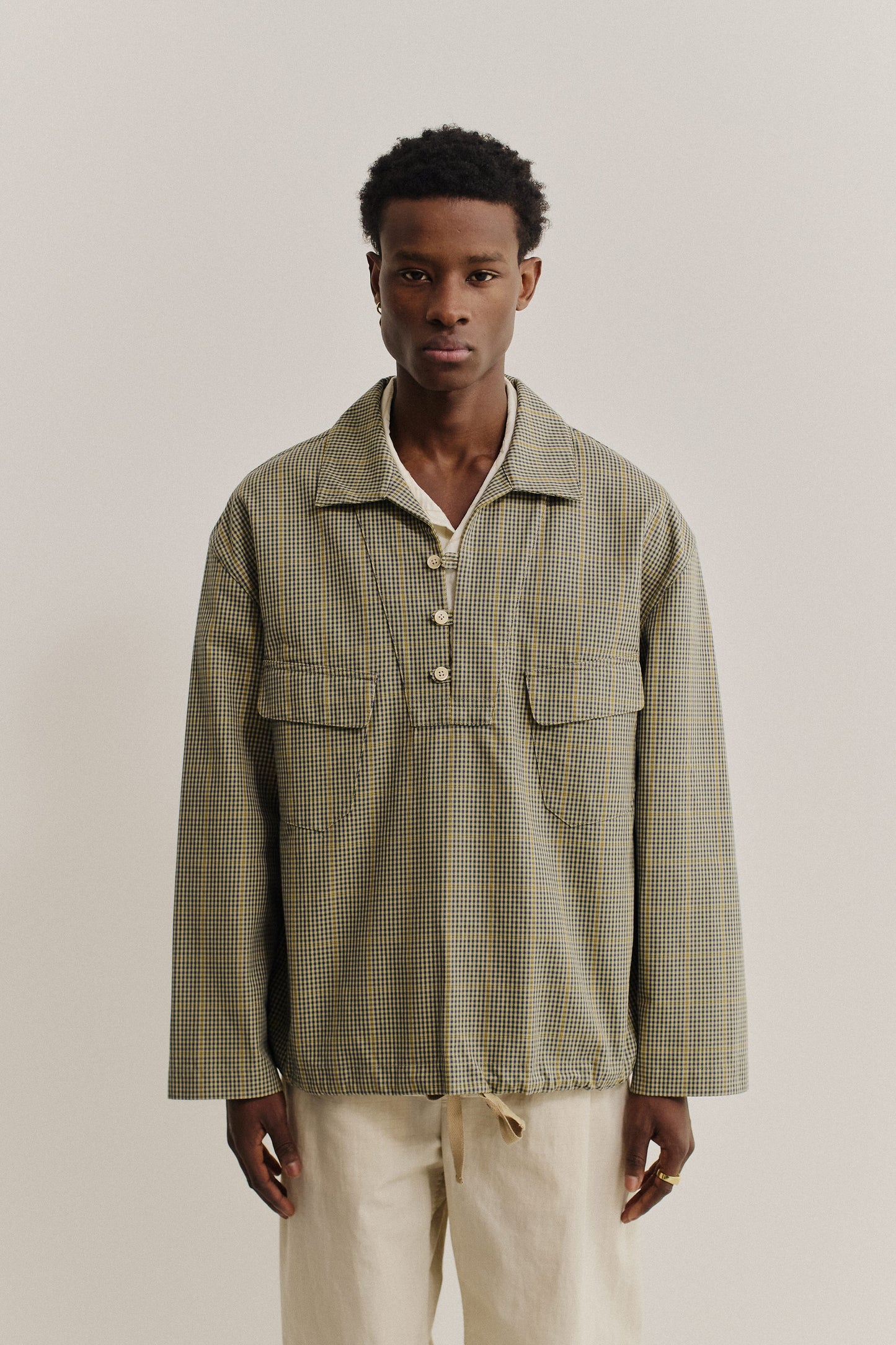 Men's long-sleeved shirt jacket, cotton houndstooth in navy, green, and yellow on beige, with patch pockets.