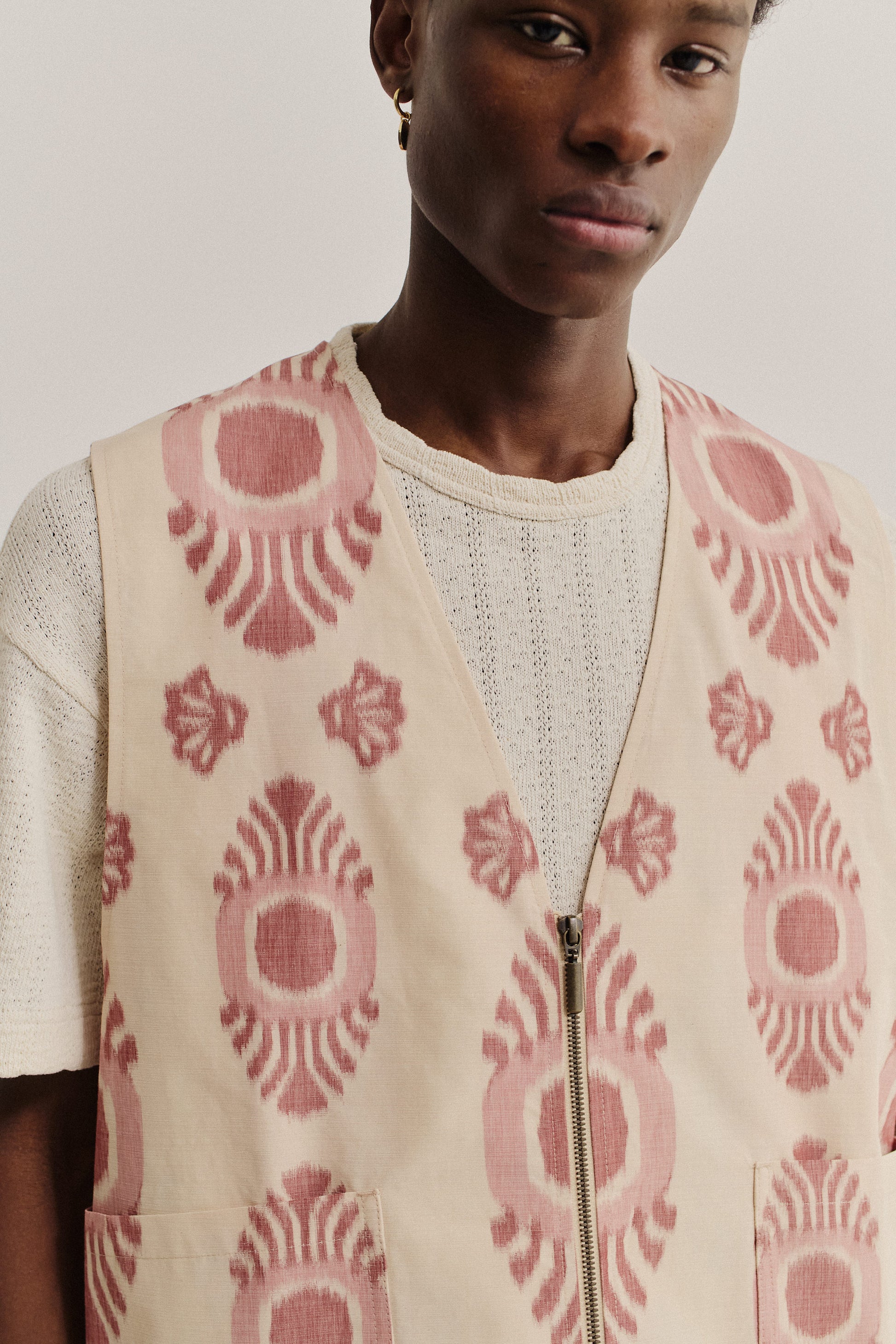 Men's outerwear vest, cotton recycled polyester blend, ikat print, beige with red pattern, metal zipper.