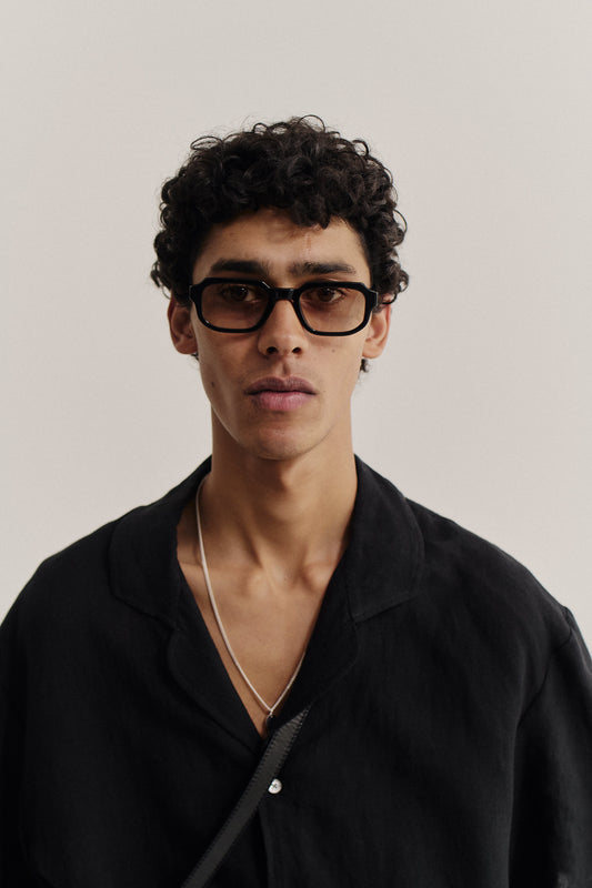 Men's accessories, rectangular black acetate sunglasses with subtly rounded edges and brown Carl Zeiss® lenses.