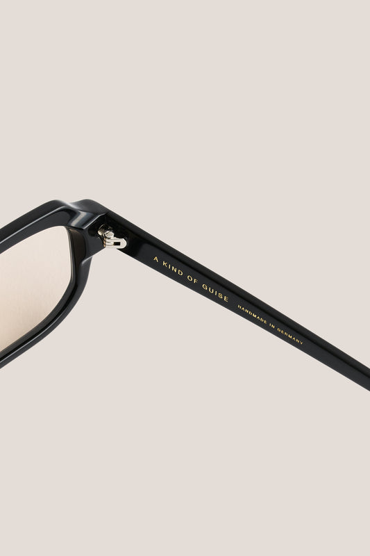 Unisex accessories sunglasses, black acetate, bold rectangular frame with subtly rounded edges and gold "A KIND OF GUISE" text.