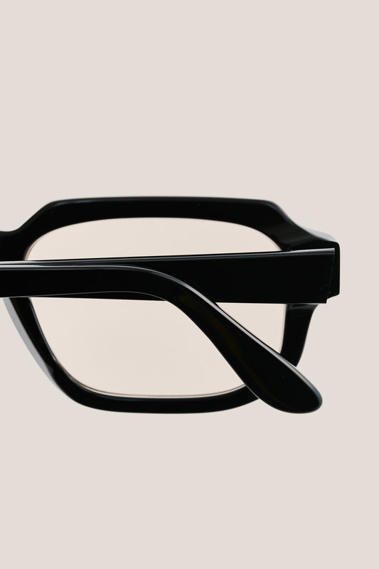 Unisex accessories sunglasses, black acetate, bold geometric rectangular frame with subtly rounded edges.