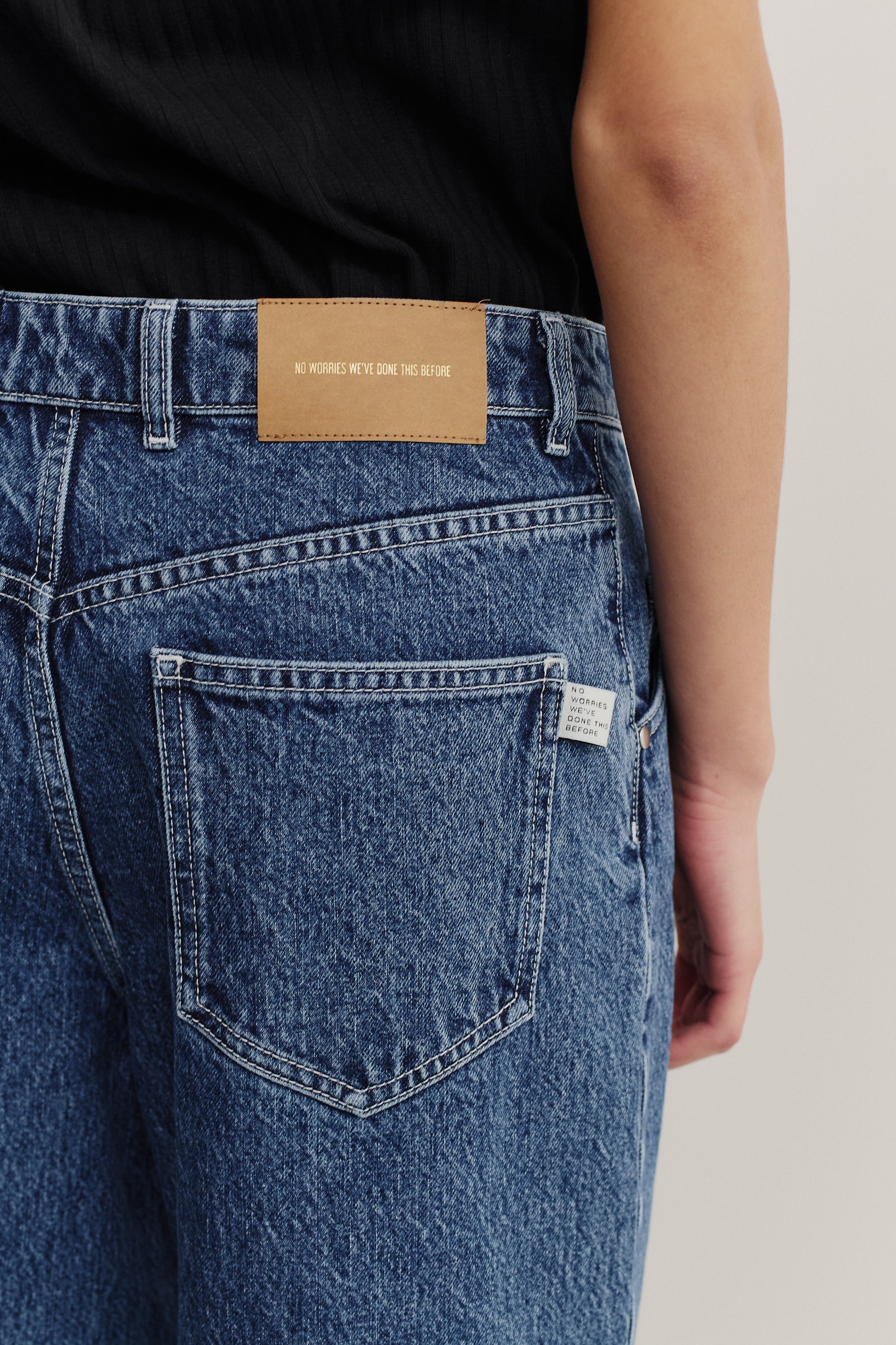 Women's long-pants, cotton mix denim, stone washed, blue. Features a brown leather patch and back pocket.