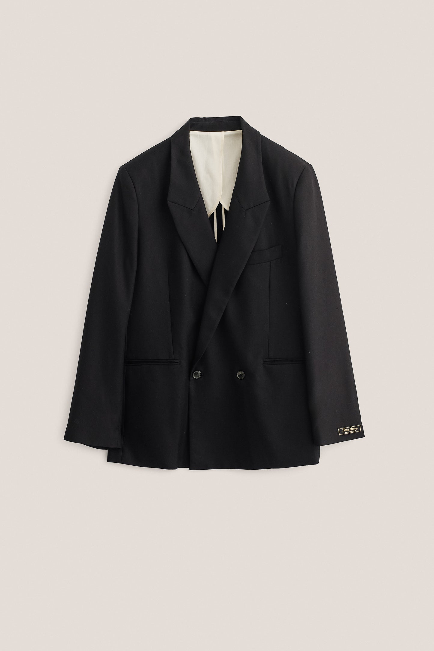 Men's tailoring, double-breasted blazer, lyocell twill, deep black, oversized fit, "stay classy" label.