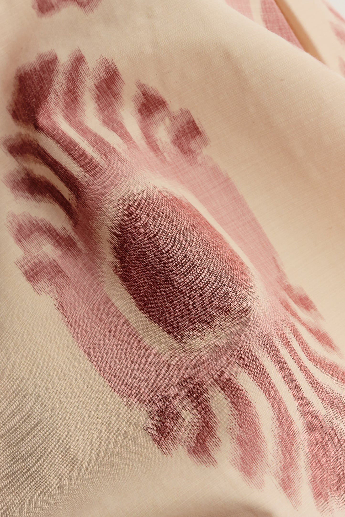 Men's long-pants, cotton and recycled polyester blend, ikat print, off-white with burgundy pattern.