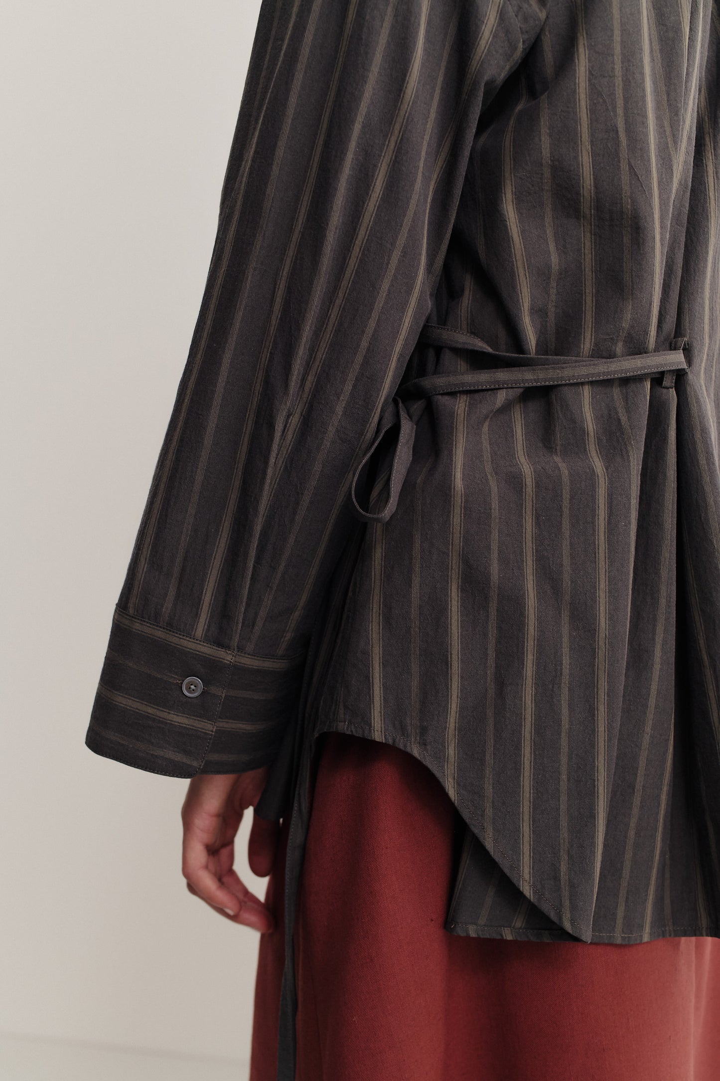 Women's long-sleeved shirt, organic cotton, yarn-dyed dark base with beige/brown stripes, curved hem, adjustable cuff.