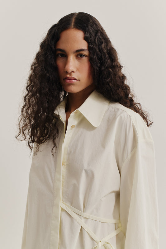 Women's long-sleeved shirt, organic cotton, garment washed, light yellow, with wide collar and folded detail.