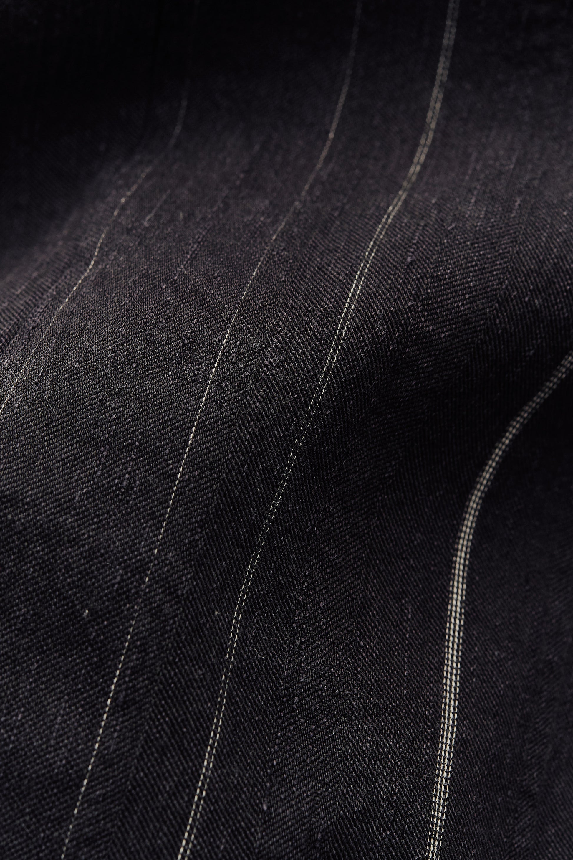 Women's jumpsuit, cotton-linen blend, black with subtle white stripes, textured, faded finish.