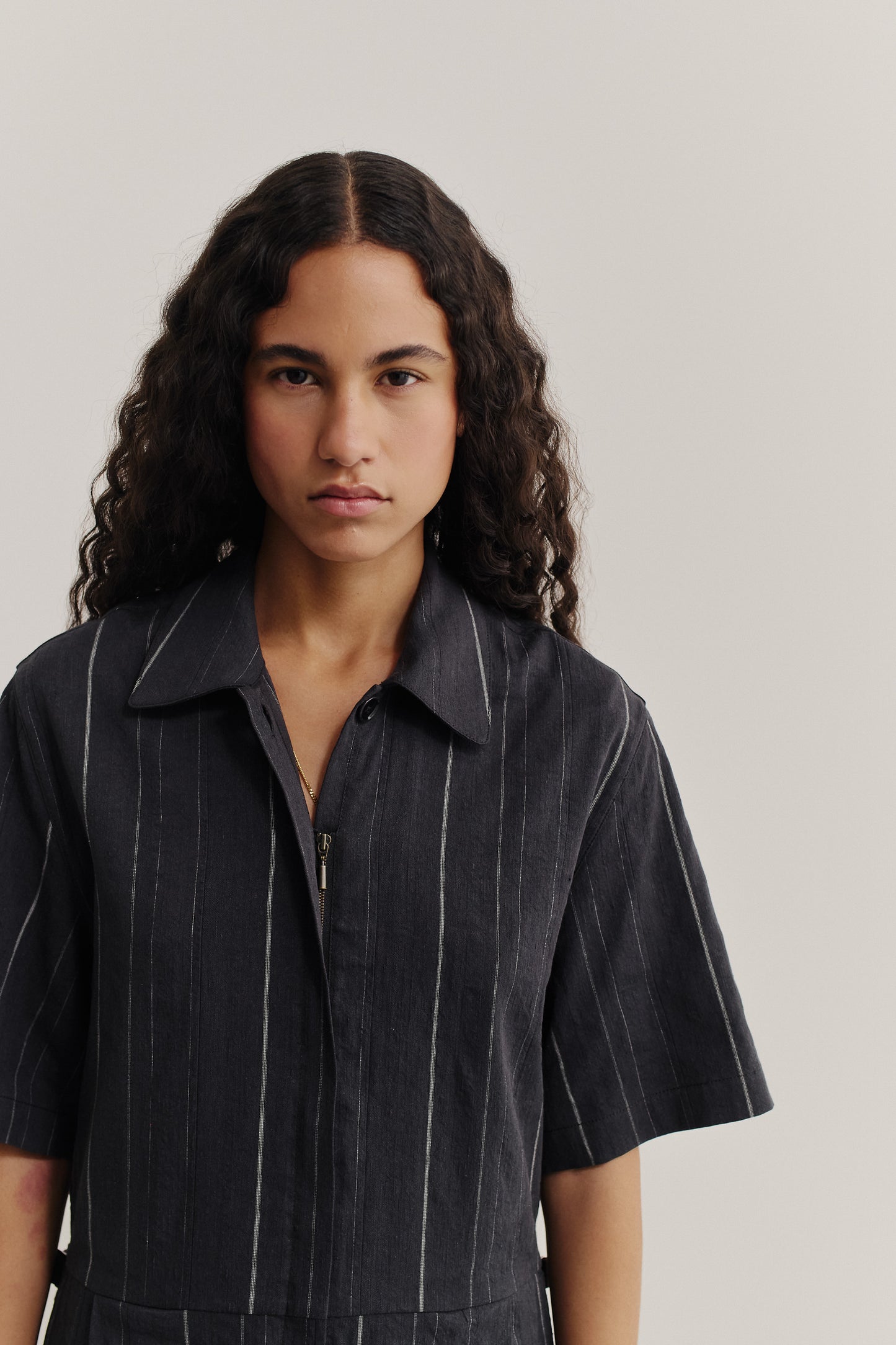 Women's jumpsuit, short-sleeved, cotton-linen blend, faded black with white stripes, lay-down collar, zipper front.